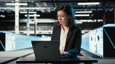 Veri merkezi mühendisi bilgisayarların bağlantı sorunlarını çözmek için dizüstü bilgisayarda klavye kullanıyor. Sunucu merkezi uzmanı sistem günlüklerini, vites hatalarını, kamera B 'yi analiz etmek için dizüstü bilgisayarı kullanıyor.