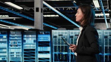 Veri merkezi mühendisi artırılmış gerçeklik kontrol paneli kullanarak sondaj kulesini yapılandırıyor. Sunucu çiftliğinde yürüyen bir kadın, donanım ayarlarını ayarlamak için sanal holografik görselleştirmeyle etkileşimde, kamera A