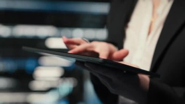 Veri merkezi yöneticisinin süper bilgisayarların bağlantı sorunlarını çözmek için kullandığı tableti kapat. Elektronik hataları çözmek için aygıt ekranındaki sistem günlüklerini analiz eden sunucu merkezi çalışanı, kamera B