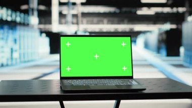 Green screen mockup laptop in data center uses to upgrade infrastructure rigs. Chroma key isolated screen notebook in empty server hub used to adjust system parameters, camera B