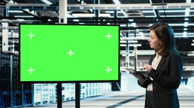 Veri merkezindeki kadın tarafından endüstriyel otomasyon sistemlerini izlemek için kullanılan krom anahtar monitörü. Sunucu odasındaki kadın yönetici ekipman performansını denetlemek için izole ekran kullanır, kamera B