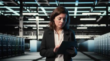 Veri merkezinde yürüyen bir mühendis, tablet kullanarak endüstriyel otomasyon sistemlerini izliyor. Ağ ekipmanı performansını denetlemek için aygıt kullanan sunucu odası bilişim uzmanı, kamera A