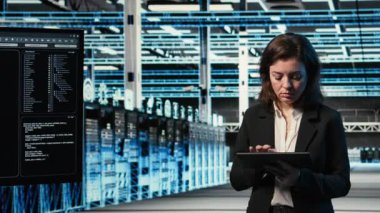 Gülümseyen veri merkezi teknisyeninin portresi AR kontrol panelini kullanarak donanımı yapılandırıyor. Donanım ayarlarını ayarlamak için tablet ve sanal holografik görselleştirme kullanan mutlu sunucu çiftlik çalışanı, kamera A