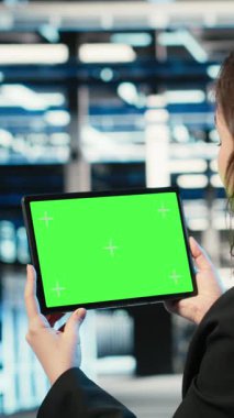 Güvenlik denetimi yapan veri merkezinde dikey video izole ekran tableti, bilişim altyapısı ve yazılım geliştiricisi. Güvenlik duvarı koruması, krom anahtar cihazı ve sunucu merkezinde çalışan kişi doğrulanıyor
