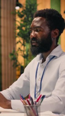 Küresel iş analizlerini ve KPI metriklerini inceleyen bir dizüstü bilgisayardaki dikey video işadamı başlangıç çalışma alanında. Görsel veriler ve organizasyon stratejisini destekleyen içgörüler, ofis araçları.