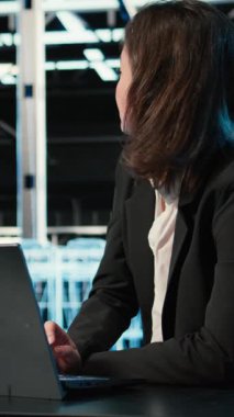 Veri merkezinde yükleme dengeleme yapan sunucu, dizüstü bilgisayar ve yazılım geliştirici dikey video optimizasyonu. Sistem parametreleri, dizüstü bilgisayar ve kadın masadaki sunucu çiftliğinde verimliliği ve kamerayı arttırıyor