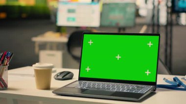 Şirket ofisindeki boş masaüstü kurulumunda dizüstü bilgisayarda yeşil ekran krom anahtar, modern mobilyalar, büyük pencereler, doğal ışık ve şehir merkezindeki gökdelen manzaralı parlak açık plan.