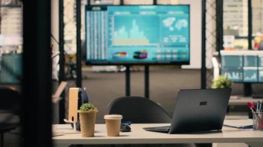 Modern mobilyaları olan boş bir iş yeri, şık dekorasyonları ve masa kurulumunda kırtasiyesi olan parlak bir açık alan. Pencereler üretkenlik için doğal ışık sağlar.