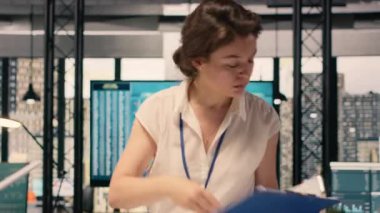 Şirket ofisindeki kadın işçi gelir verilerini ve performans ölçümlerini analiz ediyor. Analiz ve çizelge üzerinde çalışan kadın, kaynak tahsisi ve iş stratejisini destekliyor.