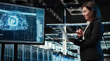 Gülümseyen veri merkezi kadın mühendisi yapay zeka sistemini geliştirdikten sonra memnun oldu. Mutlu sunucu odası yöneticisi VFX holografik veri örtüsü ile başarılı bir yapay zeka konuşlanmasından sonra gururla sunar. Kamera A