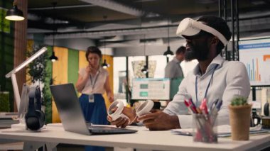 Siyahi profesyonel şirket ofis ortamında sanal gerçeklik gözlüğü kullanıyor. Yüksek teknolojili sanal gerçeklik uygulamaları, metaevren simülasyonu ve veri analizini birleştirerek, grafikleri ve performans ölçümlerini gösterir..