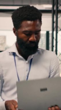 Modern ofiste çalışan dikey video işadamı iş istihbaratı ve KPI metrikleri, görsel veriler, grafikler ve örgütsel planlamayı ve profesyonel iş akışını destekleyen tahminler raporlarını analiz ediyor.