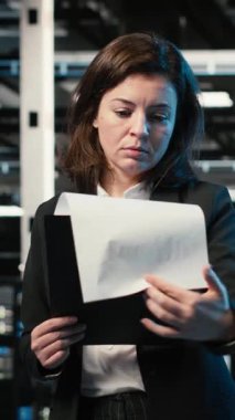 Dikey video donanım donanımı optimize etme, yapay zeka ve veri merkezindeki mühendisin gülümseme portresi. Sistem parametreleri ayarlanıyor, sunucu merkezinde yapay zeka öğrenme teknolojisi ve mutlu çalışan