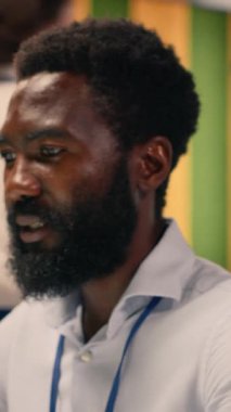 Dikey Video Siyah iş adamı, dizüstü bilgisayarda analiz, performans ölçümleri, modern ofis. Görsel veriler, grafikler ve KPI raporları, stratejik karar verme süreci, çok uluslu şirket, küresel işletme.