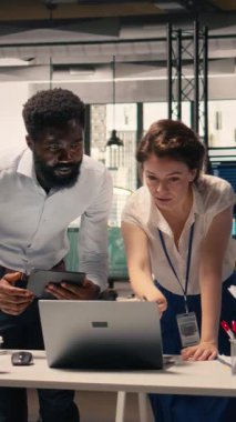 Kurumsal ofiste iş birliği yapan Dikey Video İş Ekibi raporlardaki görsel verileri, grafikleri ve grafikleri kontrol ediyor. Profesyoneller brifing oturumunda performans ölçümleri ve eylem planını tartıştılar