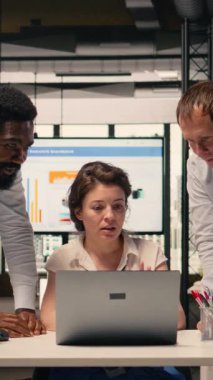 Dikey Video İş işbirliği sahnesi, çeşitli profesyoneller, dizüstü bilgisayarda birlikte çalışmak, veri analizi, KPI metrikleri, modern kurumsal çalışma alanı. Risk değerlendirmesi, kurumsal yaşam tarzı, hedefler.