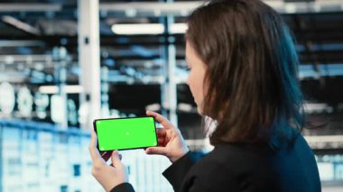 Sunucu merkezi çalışanının video izlerken kullandığı yeşil ekran akıllı telefon. Veri merkezindeki yazılım geliştirici elinde kroma anahtar cep telefonu olan, çevrimiçi kliplere bakan, kamera B