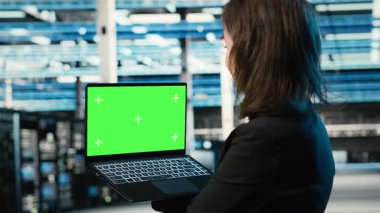 Veri merkezi geliştiricisi tarafından endüstriyel otomasyon sistemlerini izlemek için kullanılan yeşil ekran laptop. Sunucu merkezi çalışanı ekipman performansını denetlemek için maket not defteri kullanır, kamera B