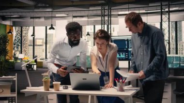 Şirket ofisinde işbirliği yapan iş ekibi raporlardaki görsel verileri, çizelgeleri ve grafikleri kontrol ediyor. Profesyoneller brifing sırasında performans ölçümleri ve eylem planını tartışırlar. Kamera A.