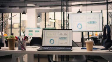 Şirket verileri boş yönetici ofisinde, modern mobilya ve ofis malzemeleriyle dekore edilmiş profesyonel çalışma ortamında gösteriliyor. Şık ofisteki hiç kimse, doğal ışık.