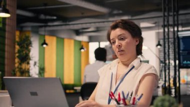 Aşırı çalışan kadın kronik yorgunluk ve tükenmişlik belirtileri gösteriyor. Yüksek sorumluluk nedeniyle etkisiz ve tükenmiş. Modern kurumsal ofiste masasında oturan yorgun ve bitkin bir kadın..