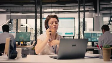 Modern ofiste telefon görüşmesi yapan iş kadını, görsel verileri gözden geçiriyor, akıllı telefon hattı, ağ kurma ve raporlama yoluyla KPI ve parasal verileri paylaşıyor. Küresel iş ve kurumsal yaşam tarzı.