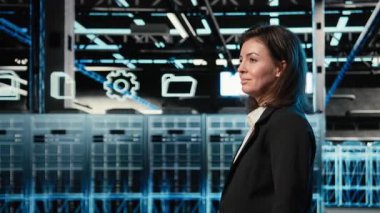 Veri merkezinde yürüyen mühendis, endüstriyel otomasyon sistemlerine bakıyor. Dijital ikiz sanal. Sunucu odası bilişim uzmanı mavi kablo ağ ekipmanı tarıyor, kamera A