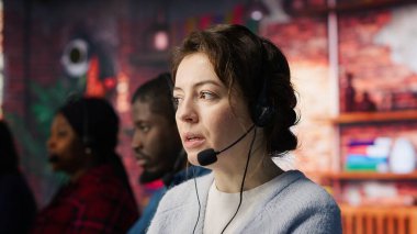 Müşteri destek çalışanları, teknik sorunlara teşhis koyarak müşterilere yardımcı oluyor. Ofiste kulaklık takan çağrı merkezi ajanları arıza giderme ve şikayet çözümü yapıyorlar.