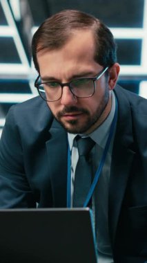 Laptop klavyesine yazıp, yazılım kullanarak kaynak optimizasyonu yapan dikey video merkezi yönetimi. Donanım süper bilgisayarlarını yükseltmek için dizüstü bilgisayar programı kullanan sunucu çiftliği bilişim uzmanı, kamera B