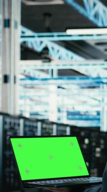 Veri merkezinde dikey video yeşil ekran dizüstü bilgisayar ve teknisyen tarafından hata ayıklama ve görselleştirme için kullanılan AR teknolojisi. Sunucu çiftlik uzmanı, kablo ağ dişlilerinde tanılama yapmak için model dizüstü bilgisayar kullanır