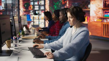 Müşteri desteği, gelen ve giden aramaları yöneten iş arkadaşları. Takım çalışması çağrı merkezi ajanları ofisin önünde müşteri sorularını cevaplamak için kulaklık kullanıyorlar, kamera B