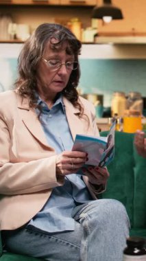 Dikey Video Üst Düzey Çifti, iyileşme için sağlık broşürlerini birlikte okuyorlar, doğru tedavi için tıbbi öneriler. Yaşlı bakımı, ev sağlığı rutini ve arkadaşlık kaliteyi artırır