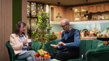 Yaşlı bir adam, salonda karısının yanında günlük ilaç tedavisine hazırlanarak hastalıkların önlenmesini ve uzun ömürlü olmasını sağlıyor. İlaç ve vitaminlerle sağlık ve zindelik, kişisel bakım.