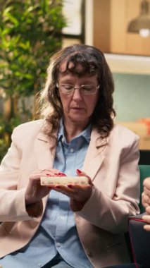 Dikey video yaşlı adam tansiyon gözlemi için okuyor ve kadın vitamin alıyor, iyileşme ve iyileşme için yaşam kalitesini arttırıyor. Emekli çift evde günlük bakım rutini yapıyor..