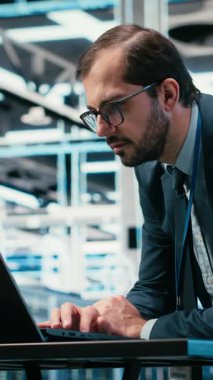 Vertical Video Veri Merkezi Mühendisi bilgisayarını ve geliştirilmiş gerçeklik simülasyonunu kullanarak bilişim altyapı veritabanı depolamasını yönetir. Sunucu çiftliğindeki adam bulut hesaplama ekipmanları donanımı, VFX 'i izliyor.