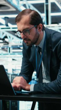 Vertical Video Veri Merkezi Mühendisi bilgisayarını ve geliştirilmiş gerçeklik simülasyonunu kullanarak bilişim altyapı veritabanı depolamasını yönetir. Sunucu çiftliğindeki adam bulut hesaplama ekipmanları donanımı, VFX 'i izliyor.