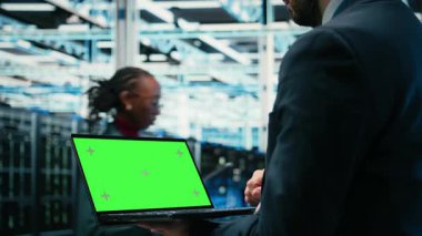 Yeşil ekran dizüstü bilgisayar, hata ayıklama sistemi ve veri merkezindeki teknisyen AR teknolojisi görselleştirmesi kullanıyor. Tanılama çalıştırılıyor, sunucu çiftliğinde kablo ağ teçhizatı ve kamera A ile modelleme defteri ve uzman