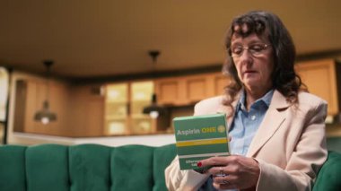 Yaşlı kadın günlük sağlık hizmetleri için ilaç kutusunda etiket okuyor. Yaşlılara yönelik reçeteli ilaç dozajının kontrol edilmesi ve evde tıbbi destek, sorumlu hastalık yönetimi.