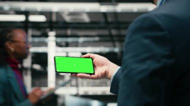 Yeşil ekran akıllı telefon, mavi kablo ağ teçhizatını yönetiyor ve veri merkezinde internet hizmetlerine yardım ediyor. Model telefon, dijital depolama sistemleri ve sunucu çiftliğinde çalışan B kameraları kullanılarak.