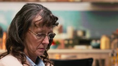 Gri saçlı ve gözlüklü mutlu yaşlı kadın portresi evde gülümsüyor, sakin sakin anları ve boş zamanları hakkında olumlu düşünüyor. Rahatlatıcı ve hayal dolu, huzurlu günlük hayat.