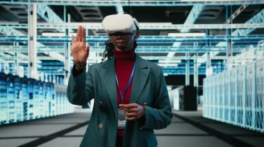 Veri merkezinde dişli teçhizatı, sanal gerçeklik gözlüğü ve kadın mühendis optimize ediliyor. Çimdikleme el hareketi, sanal gerçeklik ve sunucu odasında donanım ana bilgisayarlarını güncelleyen Afrikalı Amerikalı kadın, kamera A