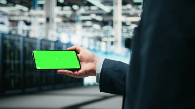 Yeşil ekran akıllı telefon, mavi kablo ağ teçhizatını yönetiyor ve veri merkezinde internet hizmetlerine yardım ediyor. Model telefon, dijital depolama sistemleri ve sunucu çiftliğinde çalışan A kamerasını kullanarak.