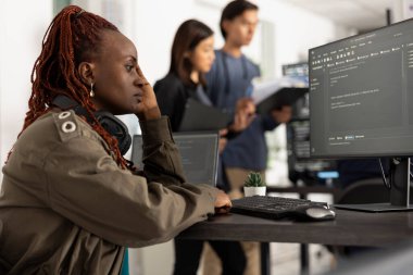 Dişi geliştirici bilgisayardaki yazılım kodlarını düzeltirken düşünmek için zaman ayırır. Programcı baskı ve konsantrasyon belirtileri gösteriyor, sorunları çözmek için çalışıyor ve tam işlevsel web sitesi.