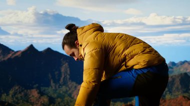 Sıcak giysili bir gezgin, yüksek irtifa keşifleriyle gelen özgürlük hissini hissederek, geniş bir dağ manzarası izler. Doğa aşığı temiz havayı sever. Kamera B.