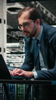 Veritabanı depolama için kullanılan bilişim altyapısını yöneten dijital video artırılmış gerçeklik simülasyonu, laptop ve mühendis veri merkezinde. Platformların izlenmesi, VFX birleşimi ve bulut hesaplama sunucusundaki adam