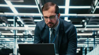 Bilgisayar klavyesinde veri merkezi yönetimi, yazılım kullanarak kaynak optimizasyonu yapıyor. Donanım süper bilgisayarlarını yükseltmek için dizüstü bilgisayar programı kullanan sunucu çiftliği bilişim uzmanı, kamera B