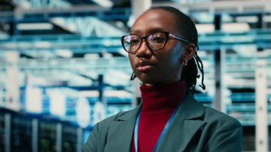 İdari ekipmanlar, gülümseyen kadın mühendis portresi ve internet hizmetlerine yardım eden veri merkezi. Sistemleri denetlemek, dijital depolama ve sunucu odasında neşeli Afrikalı Amerikalı kadın, kamera B