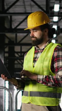 Dikey Video Mühendisliği işçisi, dizüstü bilgisayardaki performans, ağır sanayi tesisi, depo içi, sanayi bölgesi çelik işi ve büyük ölçekli fabrika üretimi.