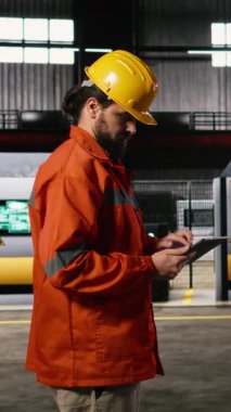 Vertical Video Industrial çalışanı, büyük ölçekli depo mühendislik fabrikasındaki ağır sanayi üretim ve imalat sürecini denetleyen tablemesiyle ağır makine operasyonlarını denetliyor..