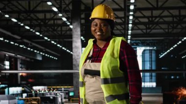 Bir fabrikada ağır sanayi operasyonlarını izleyen kadın mühendis, demir fabrikası ve endüstriyel tasarımı olan geniş bir mühendislik fabrikası. Makine dairesi. Ağır ekipmanlarla dolu büyük bir depo..